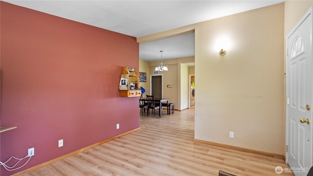 10615 SE Handicap Dr, Warden, WA 98857 - entrance foyer featuring a chandelier, light wood-style flooring, baseboards, and washer / clothes dryer