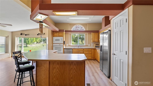 10615 SE Handicap Dr, Warden, WA 98857 - kitchen with stainless steel appliances, light wood-style floors, healthy amount of natural light, a kitchen island, and vaulted ceiling