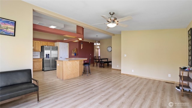 10615 SE Handicap Dr, Warden, WA 98857 - kitchen featuring stainless steel refrigerator with ice dispenser, light wood-style floors, a breakfast bar area, a ceiling fan, and a kitchen island