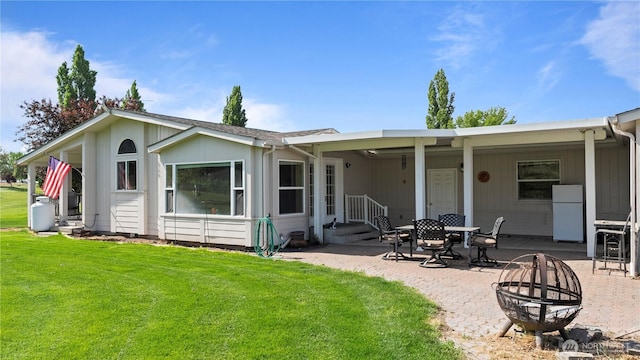 10615 SE Handicap Dr, Warden, WA 98857 - back of property with a fire pit, a lawn, a patio area, and entry steps