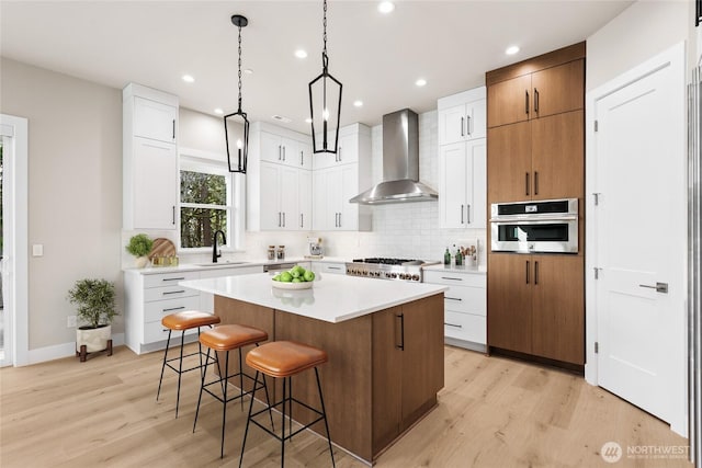 14480 133rd Pl NE, Woodinville, WA 98072 - kitchen with wall chimney range hood, light wood-style floors, a kitchen island, decorative backsplash, and recessed lighting