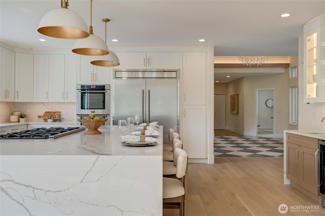 12805 Ruggs Lake Rd, Everett, WA 98208 - kitchen with stainless steel appliances, recessed lighting, white cabinetry, light stone counters, and hanging light fixtures