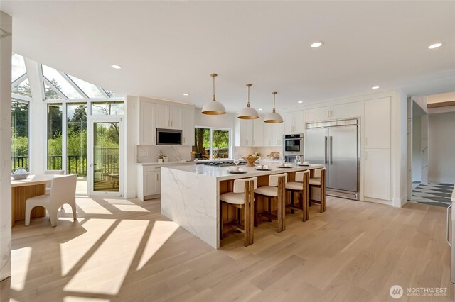 12805 Ruggs Lake Rd, Everett, WA 98208 - kitchen featuring appliances with stainless steel finishes, white cabinets, a center island, tasteful backsplash, and recessed lighting