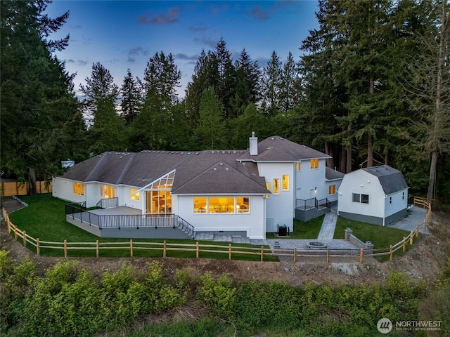 12805 Ruggs Lake Rd, Everett, WA 98208 - back of property with a wooden deck, a chimney, an outbuilding, and a forest view