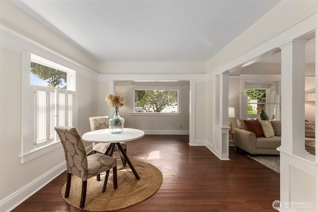 dining area with decorative columns, baseboards, and dark wood-style flooring