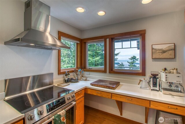 91 Coastline Dr, Orcas Island, WA 98279 - kitchen with electric stove, wall chimney exhaust hood, recessed lighting, light countertops, and dark wood finished floors