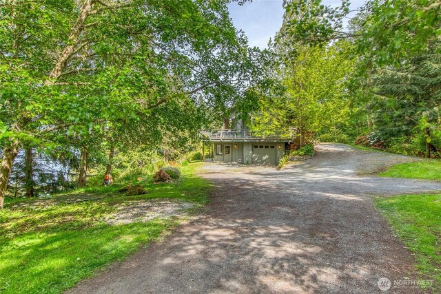 91 Coastline Dr, Orcas Island, WA 98279 - view of front of home with dirt driveway, an attached garage, and a wooden deck