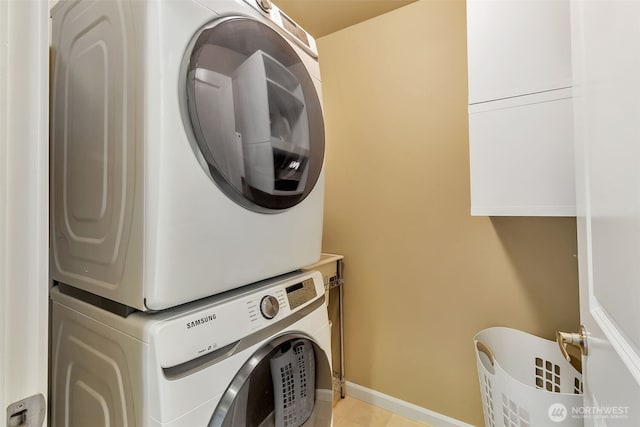 9831 NE 138th Pl, Kirkland, WA 98034 - clothes washing area with stacked washer and clothes dryer, baseboards, and light tile patterned floors