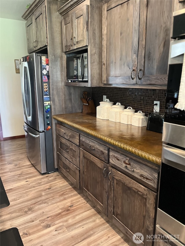 137 La Due Cemetery Rd, Onalaska, WA 98570 - kitchen with appliances with stainless steel finishes, backsplash, light wood-type flooring, and dark countertops