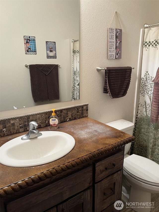 137 La Due Cemetery Rd, Onalaska, WA 98570 - full bathroom featuring vanity, toilet, decorative backsplash, and a shower with curtain
