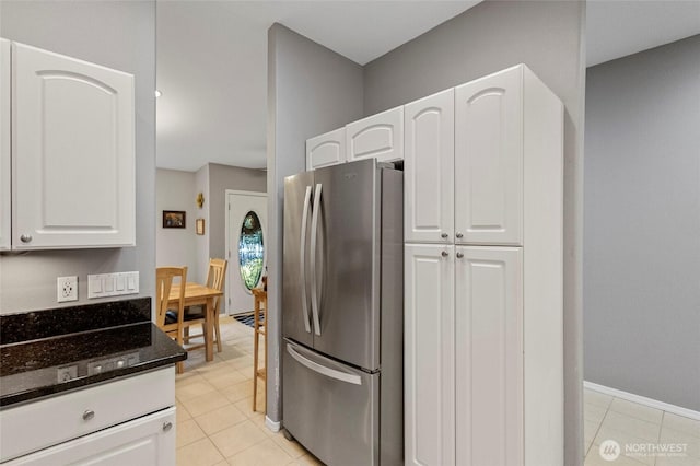 1555 Silver Lake Rd, Oak Harbor, WA 98277 - kitchen featuring freestanding refrigerator, dark stone countertops, and white cabinets