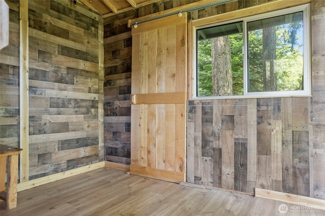 1555 Silver Lake Rd, Oak Harbor, WA 98277 - empty room featuring wood walls, plenty of natural light, and wood finished floors