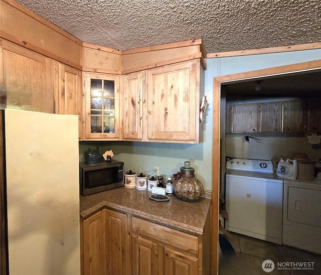 3516 Harrison Ave Unit H, Centralia, WA 98531 - kitchen featuring stainless steel microwave, freestanding refrigerator, washer and clothes dryer, glass insert cabinets, and tile patterned floors