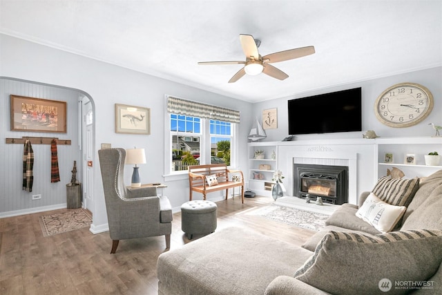 1060 Peace Portal Dr, Blaine, WA 98230 - living area with a ceiling fan, baseboards, wood finished floors, a glass covered fireplace, and built in shelves