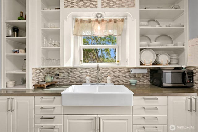 1060 Peace Portal Dr, Blaine, WA 98230 - kitchen with stainless steel microwave, open shelves, a sink, and white cabinets