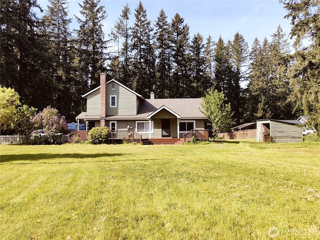 view of front of property featuring a chimney, a front lawn, an outdoor structure, and a storage shed