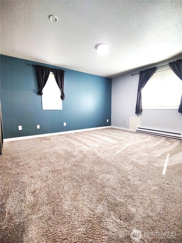 unfurnished room featuring baseboard heating, carpet flooring, baseboards, and a textured ceiling