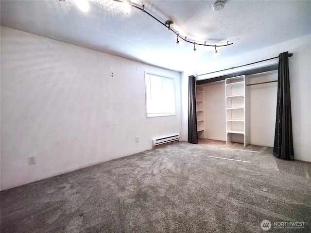 unfurnished bedroom with a baseboard heating unit, a textured ceiling, carpet flooring, and a closet