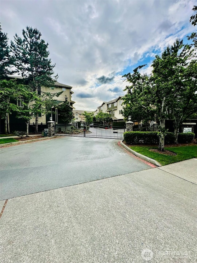 4660 NE 3rd Ct Unit J3, Renton, WA 98059 - view of asphalt road featuring a gate, curbs, and a gated entry