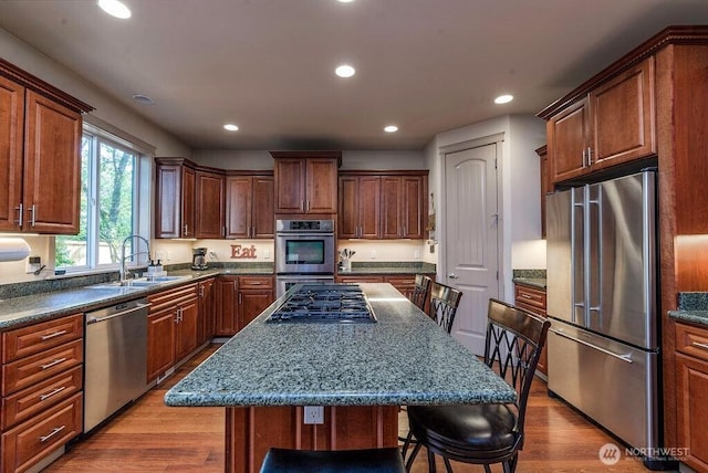 1715 131st St S, Tacoma, WA 98444 - kitchen with appliances with stainless steel finishes, a sink, a kitchen breakfast bar, wood finished floors, and recessed lighting