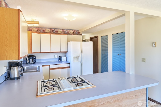 33612 I St, Ocean Park, WA 98640 - kitchen featuring white appliances, light countertops, a peninsula, and white cabinets