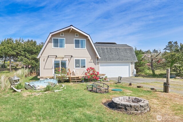 33612 I St, Ocean Park, WA 98640 - rear view of house featuring a gambrel roof, a fire pit, roof with shingles, and a lawn