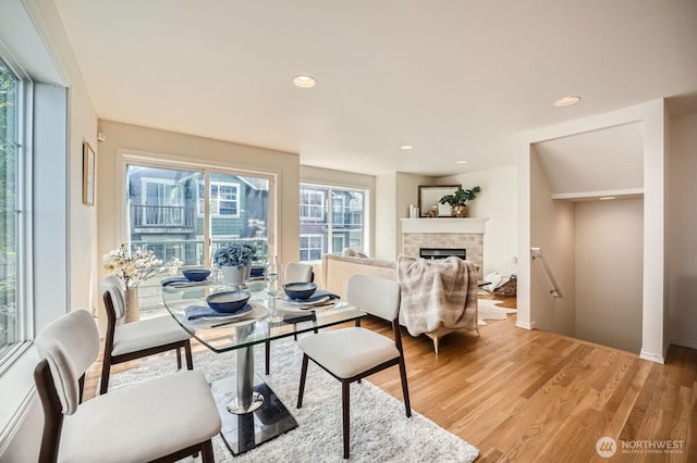 dining room featuring light wood-style flooring, a fireplace, and recessed lighting