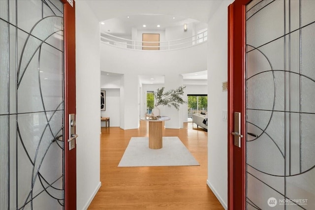 entrance foyer featuring wood finished floors, recessed lighting, and a high ceiling