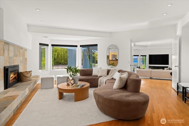 living room featuring a fireplace, wood finished floors, and recessed lighting