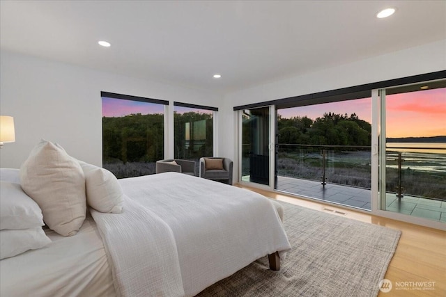 bedroom with access to exterior, wood finished floors, and recessed lighting