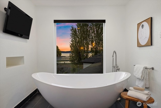 full bathroom featuring tile patterned floors, baseboards, and a soaking tub