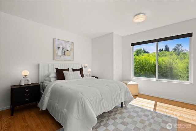 bedroom featuring wood finished floors and baseboards