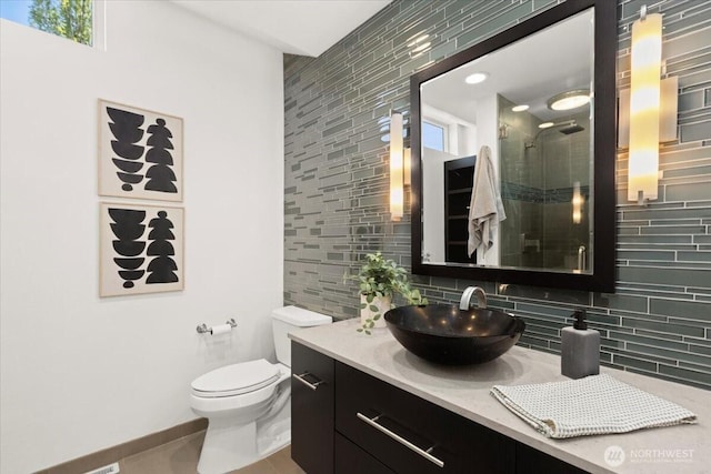 full bathroom featuring decorative backsplash, a shower stall, vanity, toilet, and baseboards