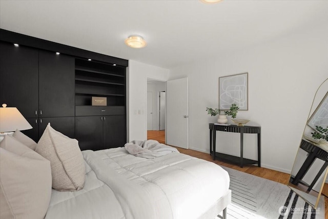 bedroom with wood finished floors and baseboards