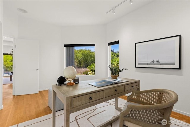 office area featuring light wood-style floors, track lighting, and baseboards