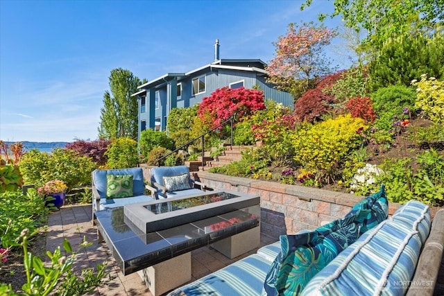 view of patio / terrace with an outdoor living space with a fire pit and stairs