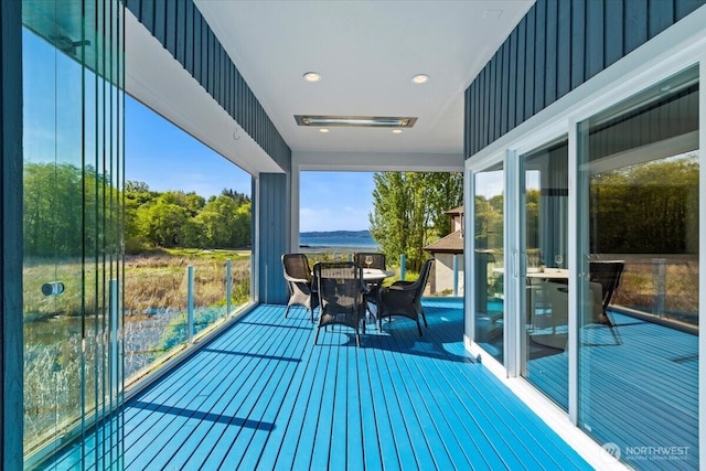 balcony with outdoor dining area and a water view