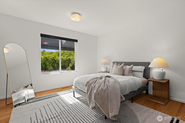 bedroom featuring baseboards and wood finished floors