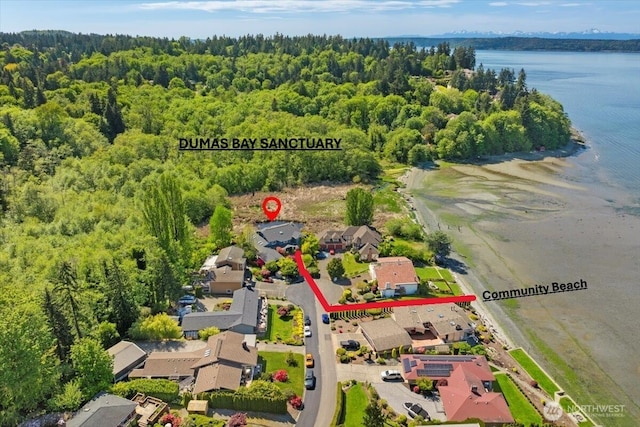 aerial view of residential area with a heavily wooded area and a nearby body of water