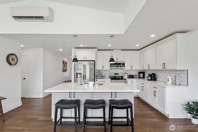 kitchen featuring stainless steel appliances, decorative backsplash, a kitchen breakfast bar, white cabinetry, and recessed lighting