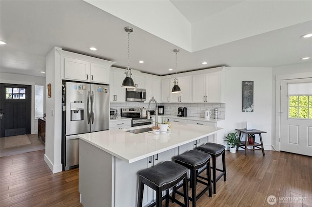 kitchen featuring appliances with stainless steel finishes, dark wood-style floors, backsplash, light countertops, and recessed lighting