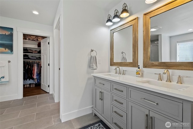 full bathroom featuring double vanity, baseboards, a spacious closet, tile patterned flooring, and recessed lighting