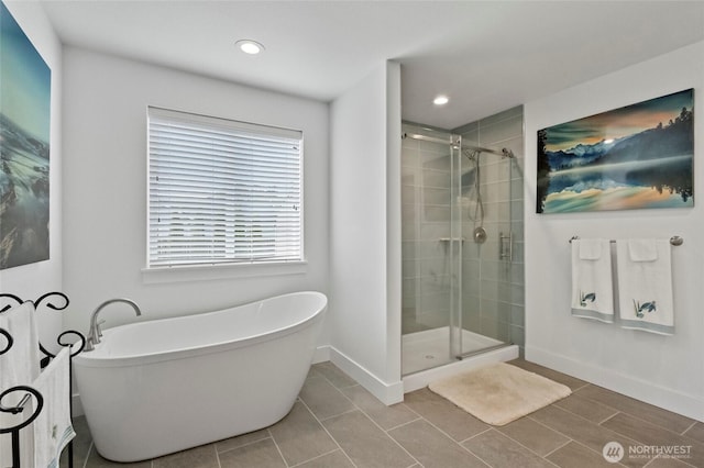full bath with baseboards, a stall shower, a soaking tub, and recessed lighting