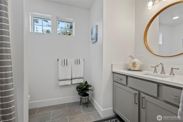 bathroom with vanity, baseboards, and tile patterned floors