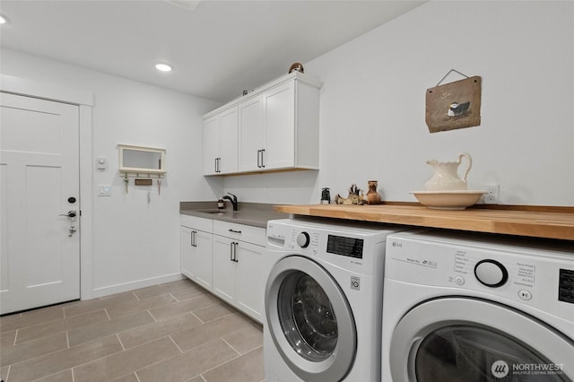 laundry room featuring washer and dryer, cabinet space, recessed lighting, and baseboards