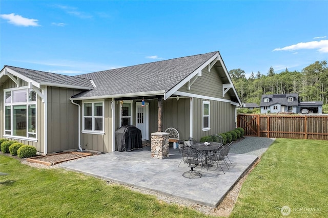 rear view of property with roof with shingles, a patio, and board and batten siding