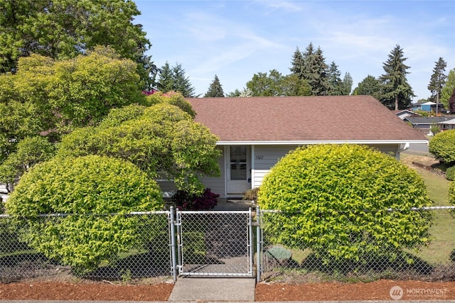 1102 S Villard St, Tacoma, WA 98465 - view of property hidden behind natural elements with a fenced front yard, a gate, and roof with shingles