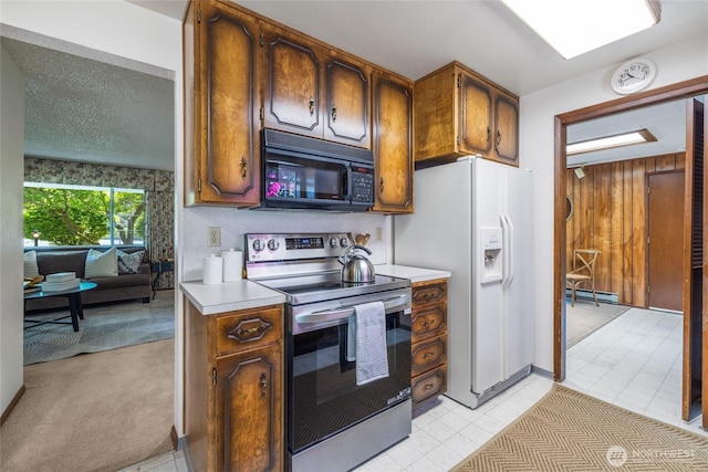 1102 S Villard St, Tacoma, WA 98465 - kitchen with black microwave, stainless steel electric stove, white fridge with ice dispenser, light countertops, and baseboard heating
