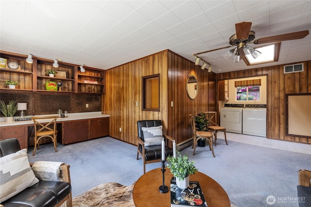 1102 S Villard St, Tacoma, WA 98465 - living area featuring washing machine and dryer, light carpet, wood walls, ceiling fan, and a baseboard radiator