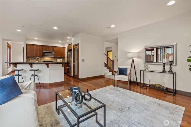 living room with recessed lighting, baseboards, dark wood-type flooring, and stairs